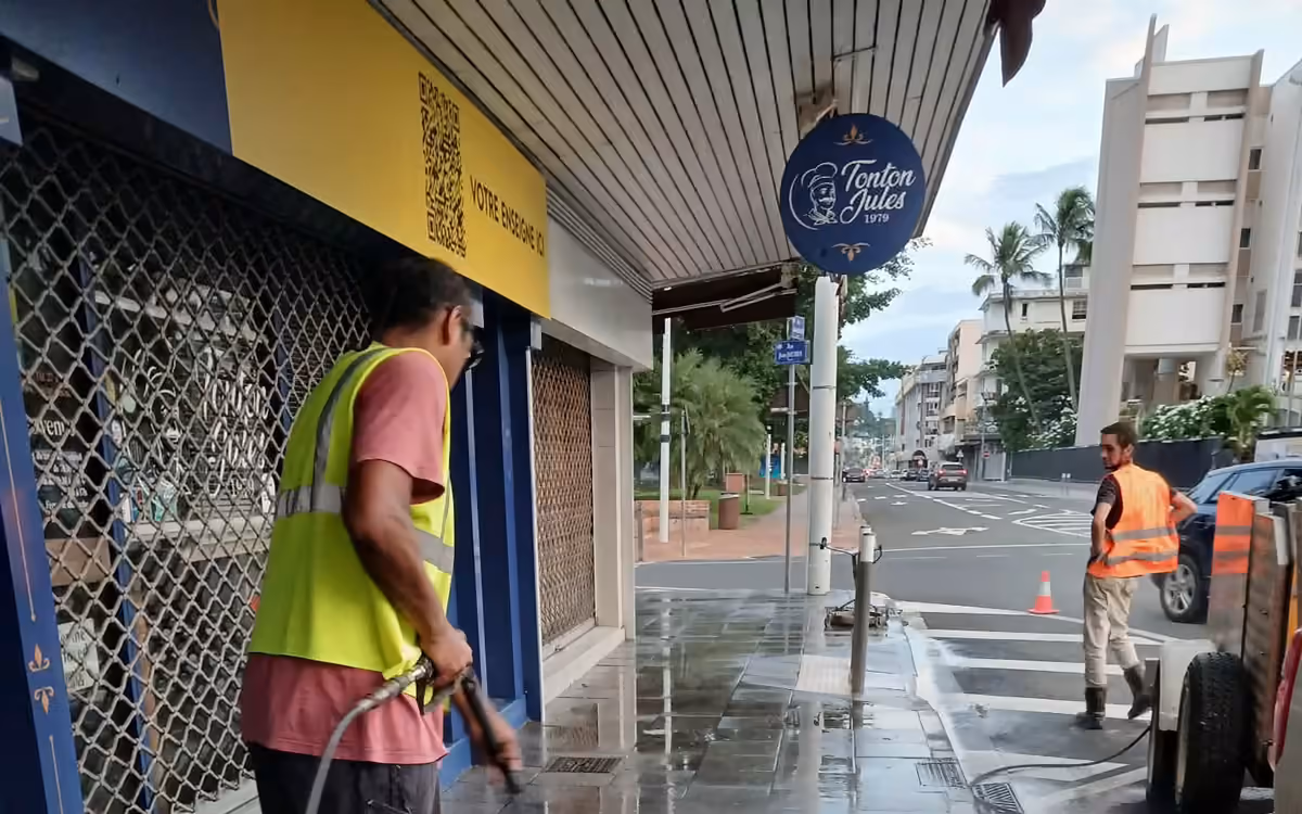 Deux techniciens ABC Support nettoyant au karcher la devanture d'un commerce à Nouméa